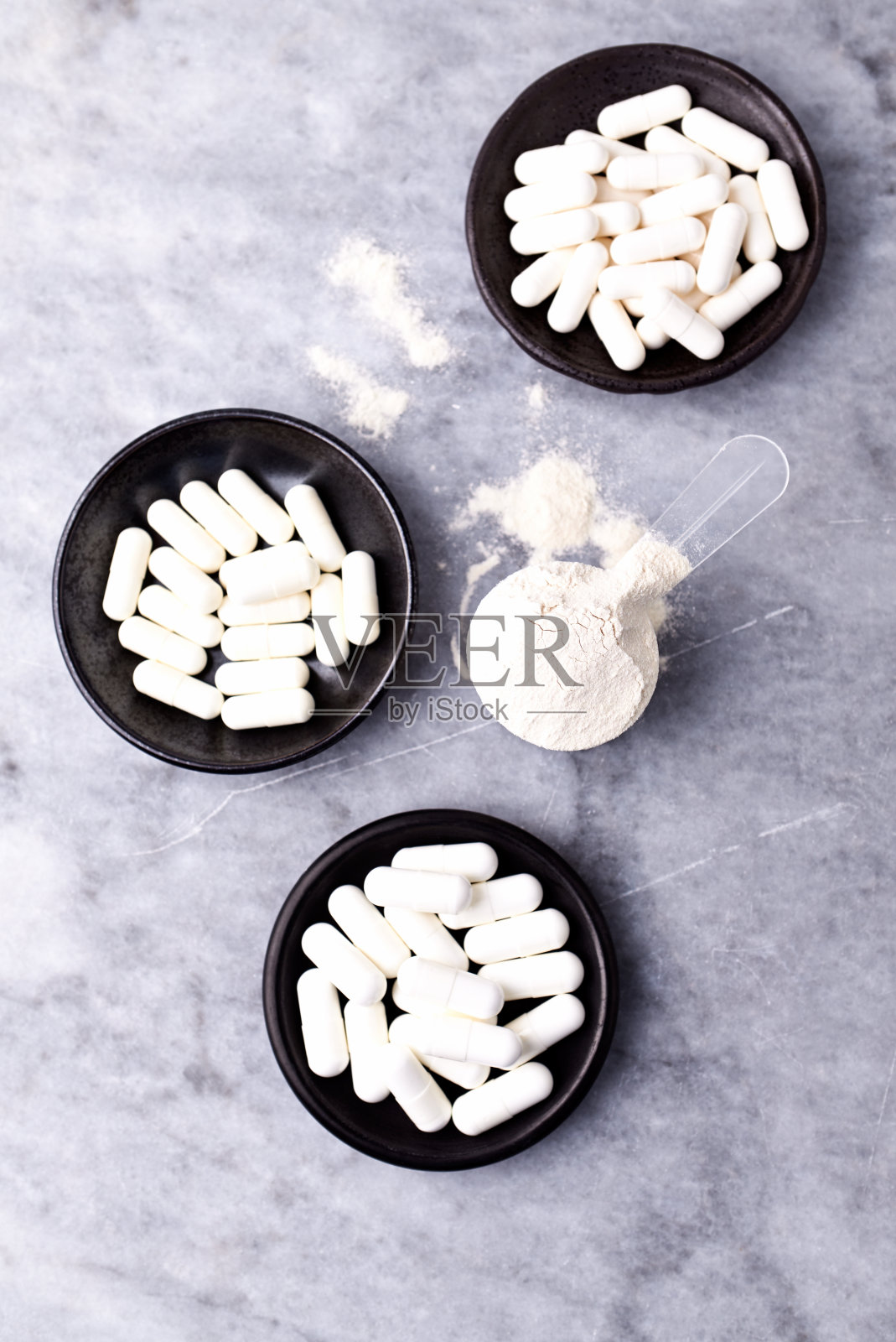 乳清蛋白,水解膠原I型,l -脯氨酸和l -賴氨酸膠囊勺。補(bǔ)充膠原蛋白的生產(chǎn)。明亮的石頭背景。直接上圖。副本的空間。